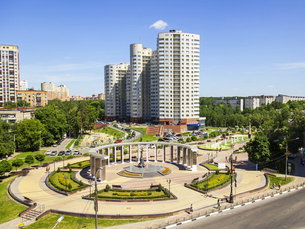 ПУШКИНО, РОССИЯ - 13 июня 2015 года. Городской пейзаж в летний полдень. Мемориал в центре города и многоэтажное новое здание
