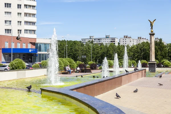 PUSHKINO, RUSIA - el 10 de mayo de 2015. Paisaje urbano en la tarde de primavera. Un monumento en el centro de la ciudad y edificios nuevos de varios pisos — Foto de Stock