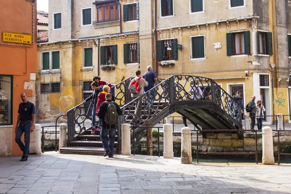 VENECIA, ITALIA - 29 DE ABRIL DE 2015. El puente con escaleras a través del canal de la calle — Foto de Stock