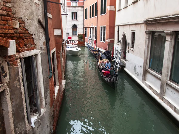 VENICE, ITÁLIA - em 3 de maio de 2015. A gôndola com passageiros flutua no canal estreito — Fotografia de Stock