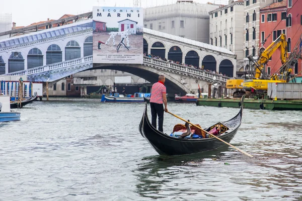 VENICE, ITÁLIA - em 3 de maio de 2015. A gôndola com passageiros flutua no Grande Canal (Canal Grande). Restauração de Ponte de Realto em um contexto — Fotografia de Stock