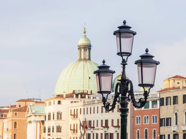 VENICE, ITALY - on MAY 4, 2015. City landscape. A characteristic streetlight on Grand kanal (Canal Grande) Embankment and a typical architectural complex on a background. — Stock Photo, Image