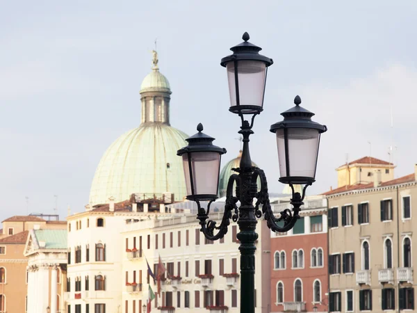 VENICE, ITALY - on MAY 4, 2015. City landscape. A characteristic streetlight on Grand kanal (Canal Grande) Embankment and a typical architectural complex on a background. — Stock Photo, Image