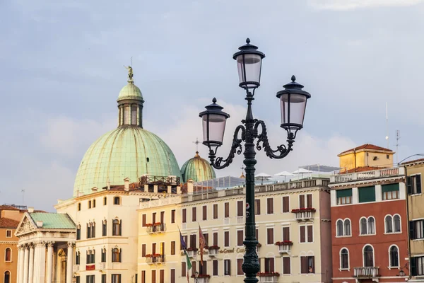 VENICE, ITALY - on MAY 4, 2015. City landscape. A characteristic streetlight on Grand kanal (Canal Grande) Embankment and a typical architectural complex on a background. — Stock Photo, Image