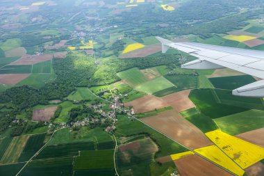 Bulutlar ve bir karasal yüzey üzerinde uçan uçağın penceresinden görüntülemek