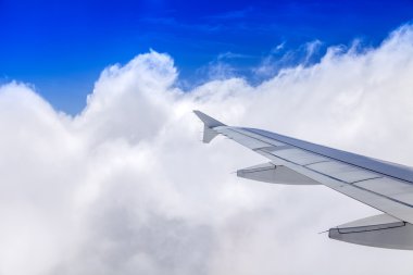 Uçak Görünümü penceresinden pitoresk beyaz bulutlar ve uçağın kanat