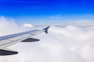 Uçak Görünümü penceresinden pitoresk beyaz bulutlar ve uçağın kanat