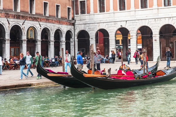 VENICE, ITALY - on MAY 4, 2015. Walk on a gondola on the Grand channel (Canal Grande) - one of the most known tourist attractions in Venice. Passengers take places in a gondola — Stock Photo, Image