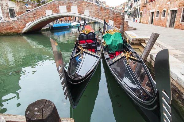 VENISE, ITALIE - le 4 mai 2015. Les gondoles sont amarrées sur la côte du canal. Palais anciens sur le remblai — Photo
