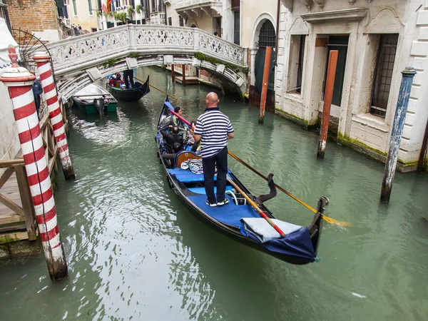VENICE, ITALY - on MAY 4, 2015. Walk on a gondola on venetian channels  - one of the most known tourist attractions in Venice. — Stock Photo, Image