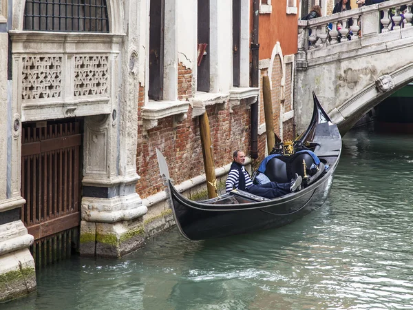 VENICE, ITALY - on MAY 4, 2015. The typical Venetian street canal and its reflection in water. The lonely gondola with passengers floats — 스톡 사진