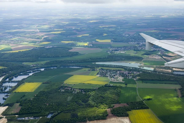 A visão superior de uma janela do avião voador na cidade e as suas vizinhanças — Fotografia de Stock