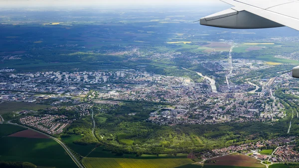 La vista superior desde una ventana del avión volador sobre la ciudad y sus alrededores — Foto de Stock