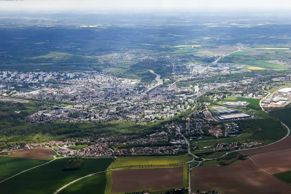 都市とその周辺に飛ぶ飛行機の窓から平面図 — ストック写真
