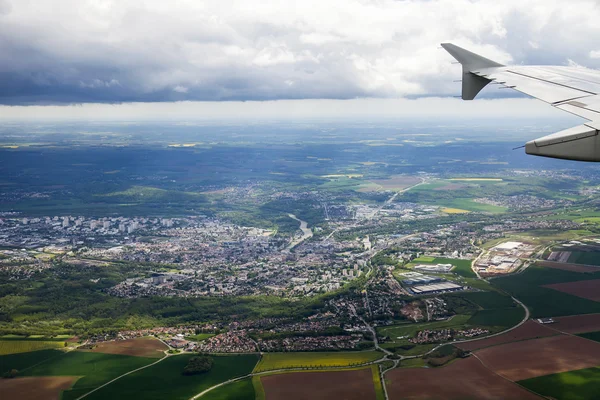 The top view from a window of the flying plane on the city and its vicinities