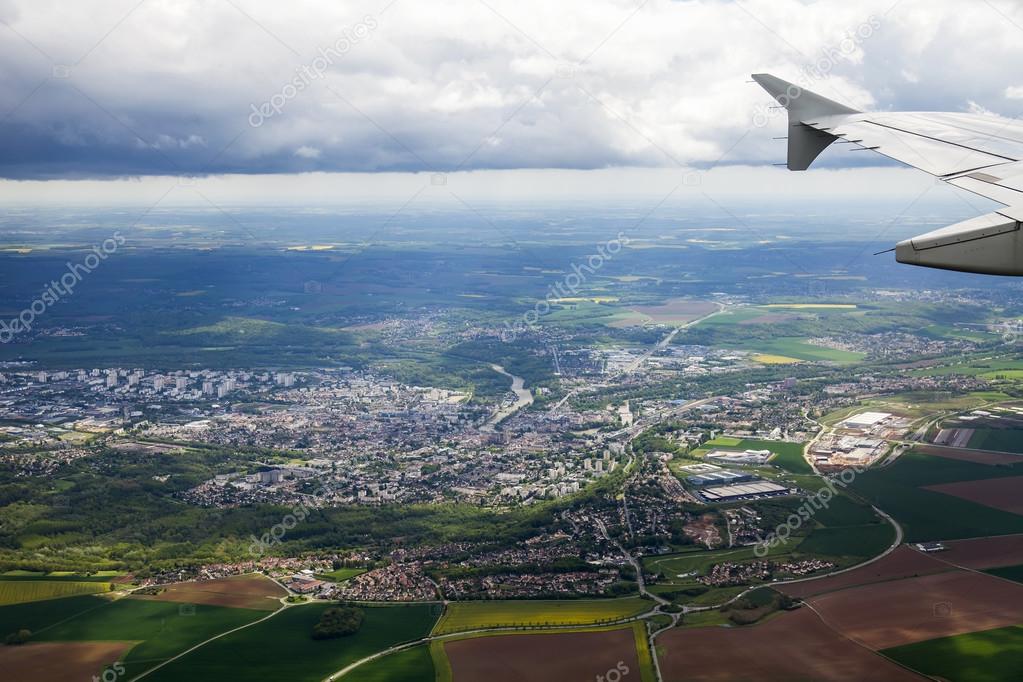 The top view from a window of the flying plane on the city and its vicinities