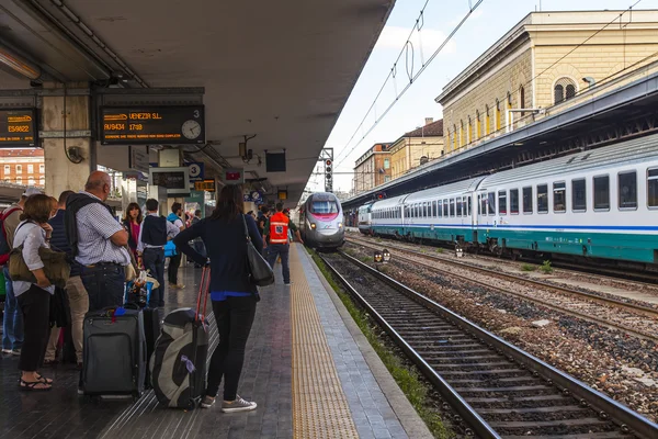 ボローニャ、イタリア、2015 年 5 月 2 日に。乗客は中央駅のプラットホームで列車の到着を期待します。 — ストック写真