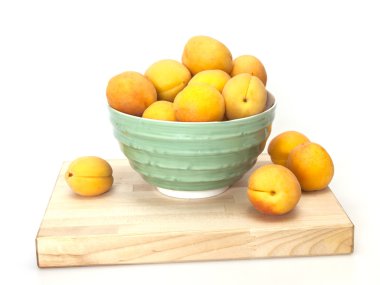 Yeşil bir kabın içinde olgun kayısı