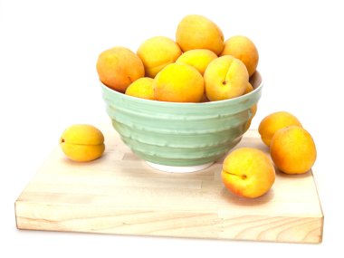 Yeşil bir kabın içinde olgun kayısı