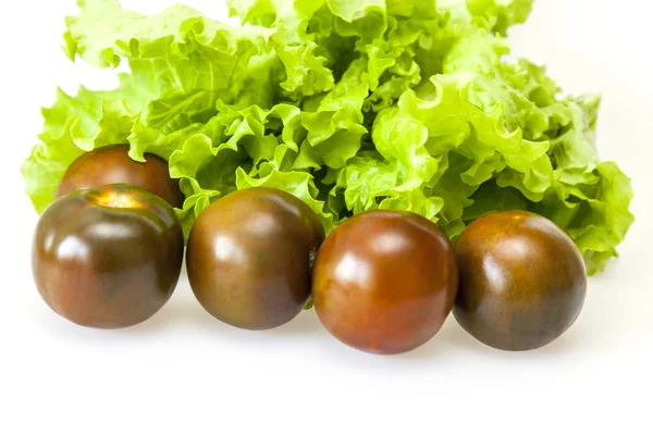 Feuilles de salade fraîche et tomates noires — Photo
