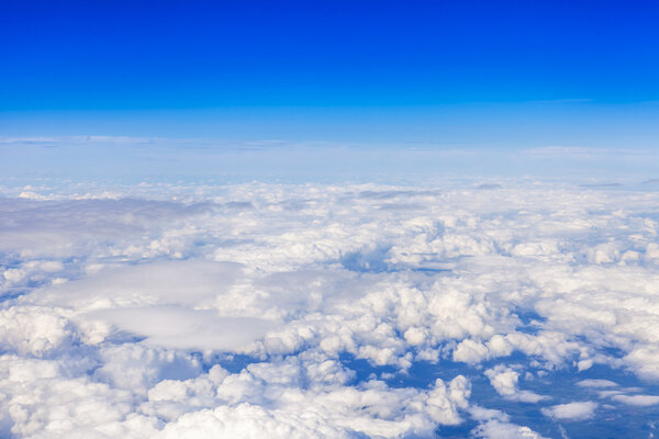 Живописный райский пейзаж. Вид из окна самолета, пролетающего над облаками
