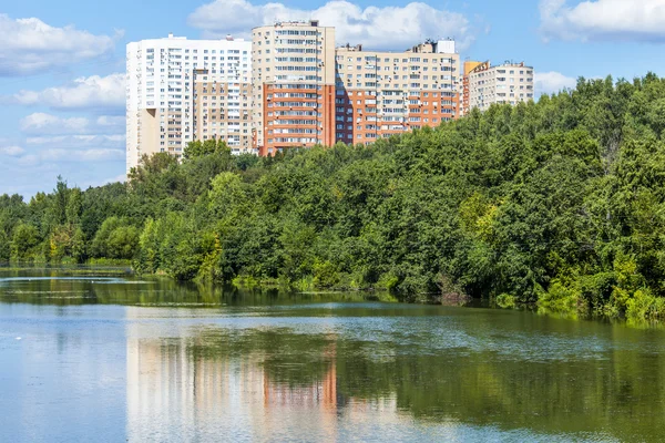 Pushkino, Rusko, na 11 srpna 2015. Městské krajině v létě odpoledne. Multystoried domy se odrážejí v řece si Serebryank — Stock fotografie