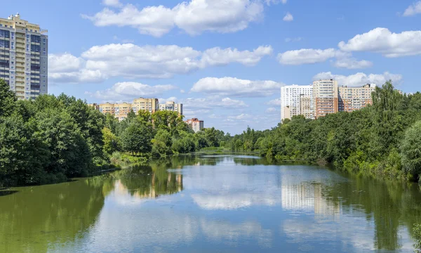 PUSHKINO, RUSIA, 11 de agosto de 2015. Paisaje urbano en la tarde de verano. Casas de varios pisos se reflejan en el río Serebryanka —  Fotos de Stock