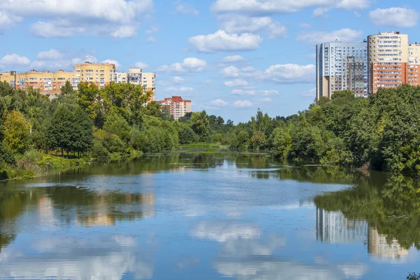 PUSHKINO, RUSSIA, on Aug 11, 2015. Яркий летний день. Многоэтажные дома и парк на берегу реки Серебрянка — стоковое фото