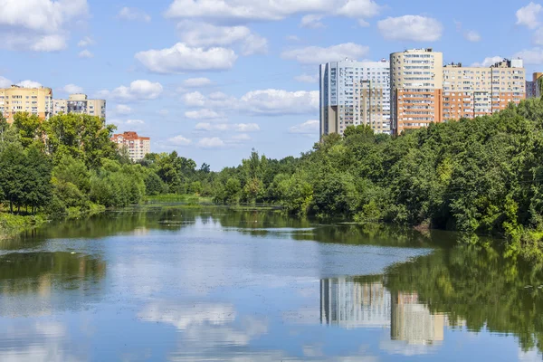PUSHKINO, RUSIA, 11 de agosto de 2015. Día de verano brillante. Casas de varios pisos y parque en la orilla del río Serebryanka — Foto de Stock