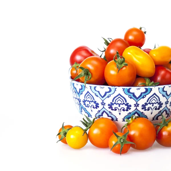 Cherry tomatoes of various grades in a bowl with a blue pattern — Stock Photo, Image