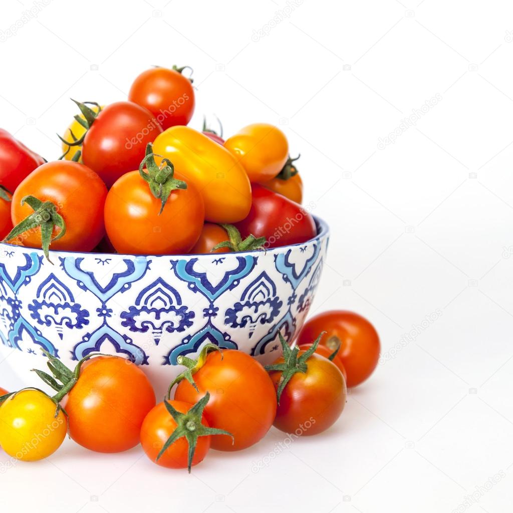 Cherry tomatoes of various grades in a bowl with a blue pattern