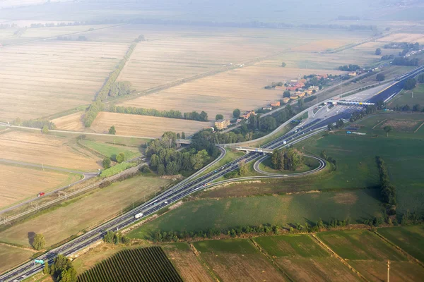 Uitzicht vanuit het raam van de vliegende vliegtuig op wolken en een terrestrische oppervlak hieronder — Stockfoto