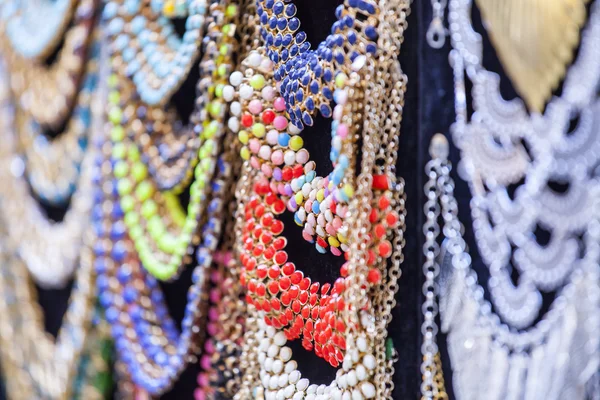 Bright costume jewelry of various colors on a show-window of shop — Stok fotoğraf