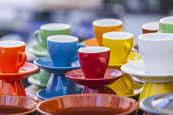 Bright coffee cups of various colors on a show-window of shop — Zdjęcie stockowe