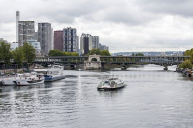 PARIS, FRANCE, on SEPTEMBER 1, 2015. A view of Seine and the walking ships moored to the embankment. Pont de Bir Hakeim in Paris. Famous bridge over the river Seine.