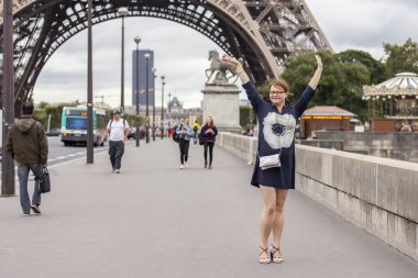Paris, Fransa, 1 Eylül 2015 tarihinde. Eyfel Kulesi karşı mutlu turist. Eyfel Kulesi dünyanın en çok ziyaret edilen ve tanınabilir yerler biridir