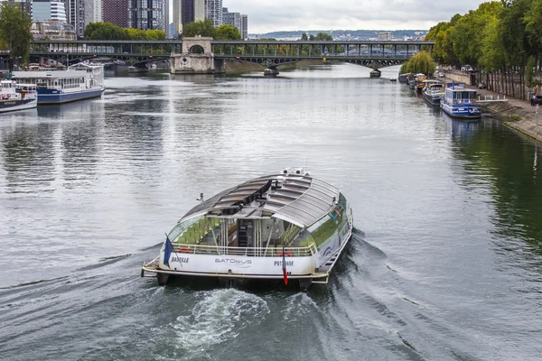 PARIS, FRANCE, on SEPTEMBER 1, 2015. A view of Seine and the walking ships moored to the embankment. Pont de Bir Hakeim in Paris. Famous bridge over the river Seine. — стокове фото