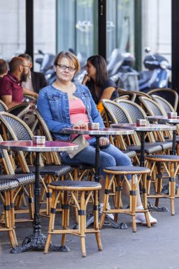 26 Ağustos 2015 tarihinde, Paris, Fransa. Kadın sokak şehir yaz kafede bir masada oturur