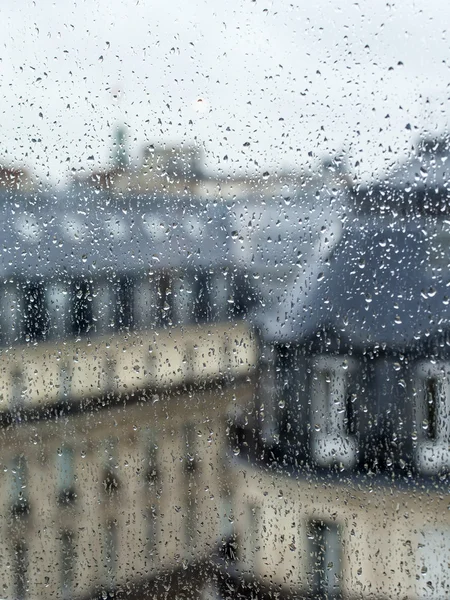 Paříž, Francie, na 27 srpnu 2015. Pohled z okna na město v deštivém počasí. Střechy Paříže mokré od deště, kapka deště na sklo — Stock fotografie