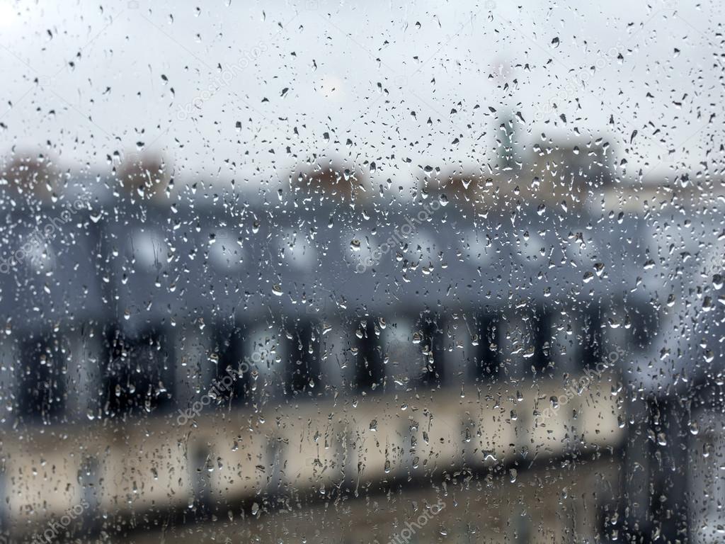 PARIS, FRANCE, on AUGUST 27, 2015. A view from the window on the city in rainy weather. Roofs of Paris wet from a rain, a rain drop on glass