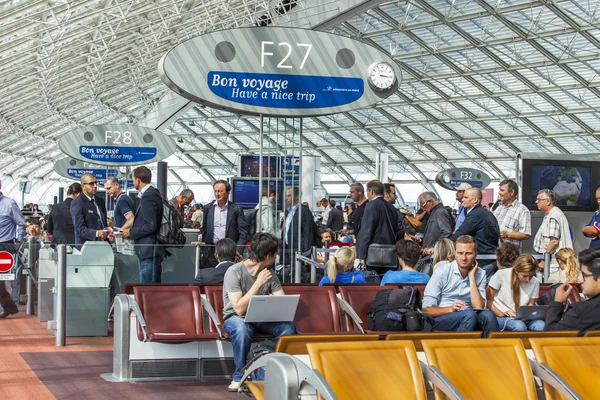 Paris, Frankrike - den 1 September 2015. Den internationella flygplatsen Charles de Gaulle, passagerare i en hall med en avgång förvänta ombordstigning — Stockfoto