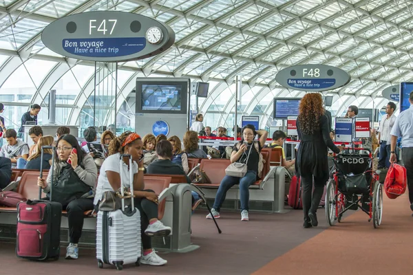 Paris, Frankrike - den 1 September 2015. Den internationella flygplatsen Charles de Gaulle, passagerare i en hall med en avgång förvänta ombordstigning — Stockfoto