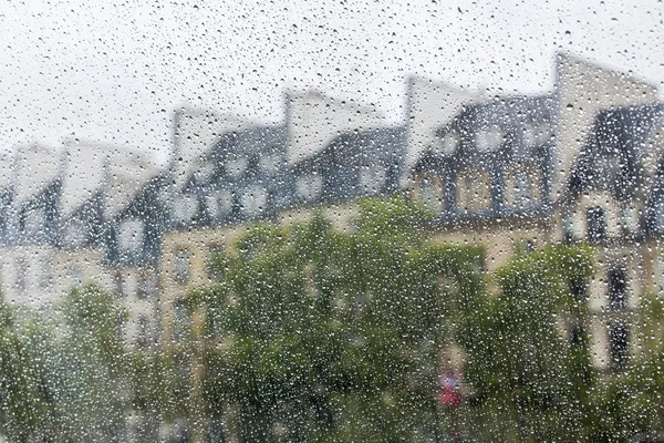 PARIS, France, le 29 SEPTEMBRE 2015. Paysage parisien. Une vue sur les toits de la ville à travers une fenêtre mouillée sous une pluie — Photo