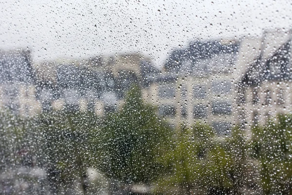 PARIS, FRANCE, on SEPTEMBER 29, 2015. Parisian landscape. A view of city roofs through a wet window during a rain