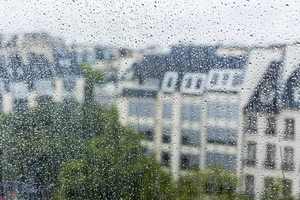 Париж, Франция, 27 августа 2015 г. Фрагмент архитектурного комплекса площади перед Центром Жоржа Помпиду, смотрящего в мокрое окно. Дождь, капли воды на стекло, фокус на капли — стоковое фото