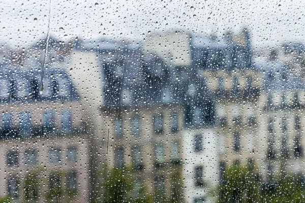 PARIS, FRANCE, on AUGUST 27, 2015. A fragment of an architectural complex of the square in front of the Centre Georges Pompidou, a look through a wet window. It is raining, water drops on glass, focus on drops — стокове фото