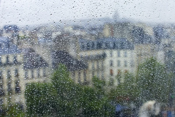 PARIS, FRANÇA, em 27 de agosto de 2015. Um fragmento de um complexo arquitetônico da praça em frente ao centro Georges Pompidou, um olhar através de uma janela molhada. Está chovendo, gotas de água no vidro, foco em gotas — Fotografia de Stock