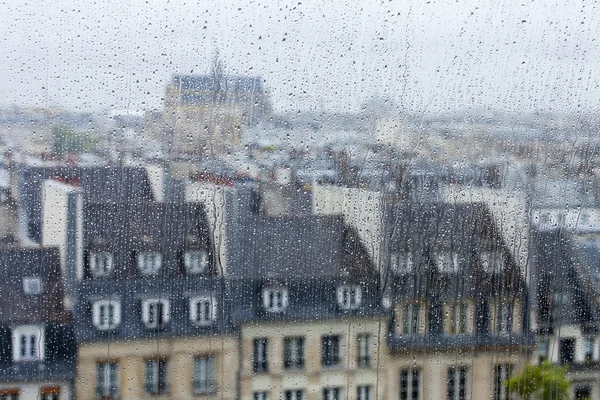 PARIS, France, le 29 SEPTEMBRE 2015. Paysage parisien. Une vue sur les toits de la ville à travers une fenêtre mouillée sous une pluie — Photo