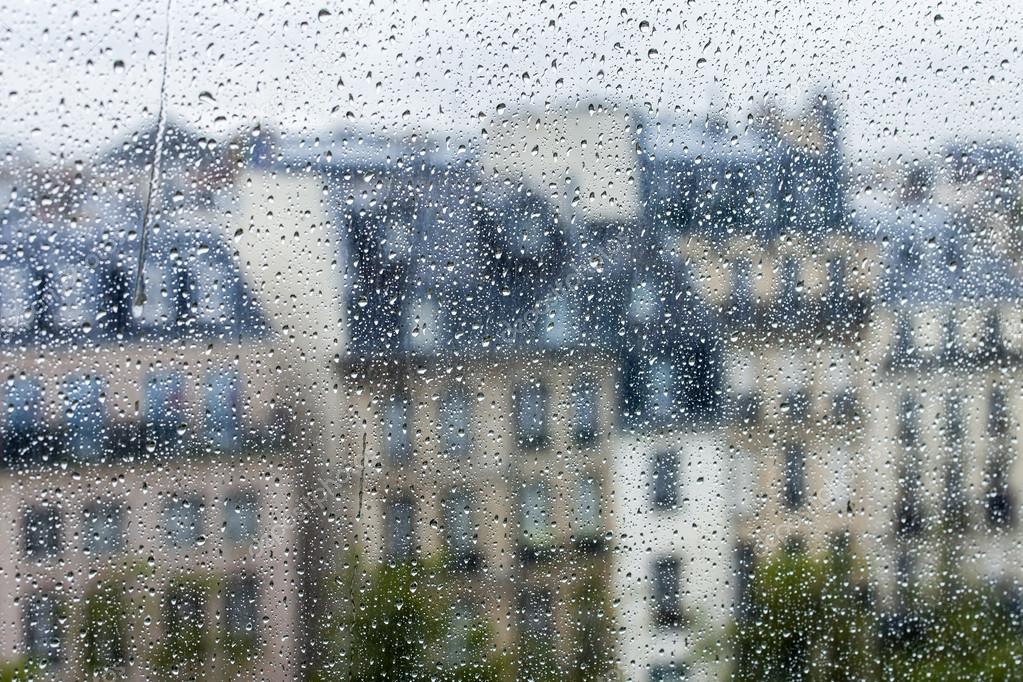 PARIS, FRANCE, on AUGUST 27, 2015. A fragment of an architectural complex of the square in front of the Centre Georges Pompidou, a look through a wet window. It is raining, water drops on glass, focus on drops