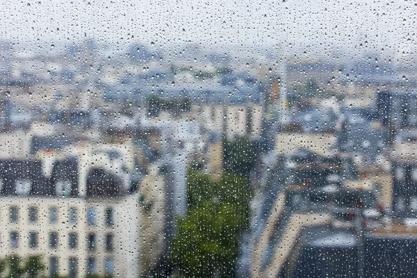 PARIS, FRANCE, le 27 septembre 2015. Vue sur la ville depuis une fenêtre depuis un point culminant sous une pluie. La pluie tombe sur le verre. Focus sur les gouttes — Photo
